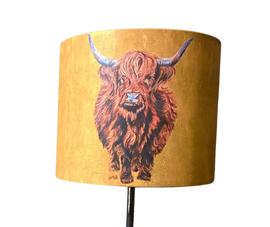 A printed lampshade with brown highland cow on a mustard yellow background